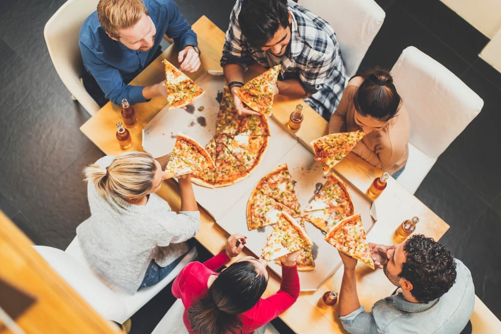 Group sharing pizzas around a table